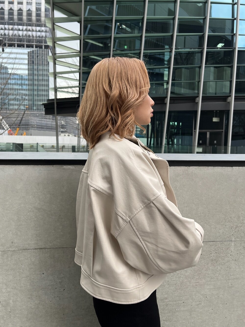 ホワイト系のブルゾン、ブラック系のニット/セーター、ブラック系のデニムパンツを着用したレディースの冬コーディネートの7枚目の写真