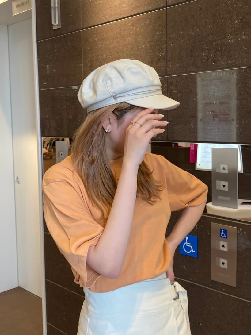 ホワイト系のスカート、オレンジ系のTシャツ/カットソー、ホワイト系のサンダルを着用したレディースの春コーディネートの6枚目の写真