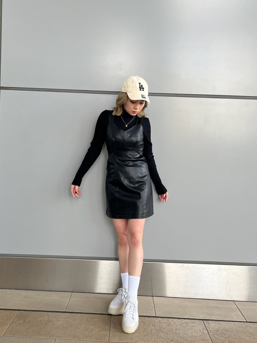 ブラック系のワンピース、ブラック系のニット/セーター、グレー系のスニーカーを着用したレディースの冬コーディネートの2枚目の写真