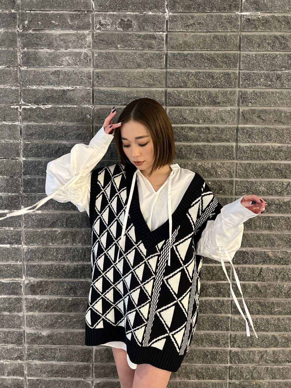 ホワイト系のシャツ/ブラウス、その他のベスト、ブラック系のブーツを着用したレディースの冬コーディネートの4枚目の写真