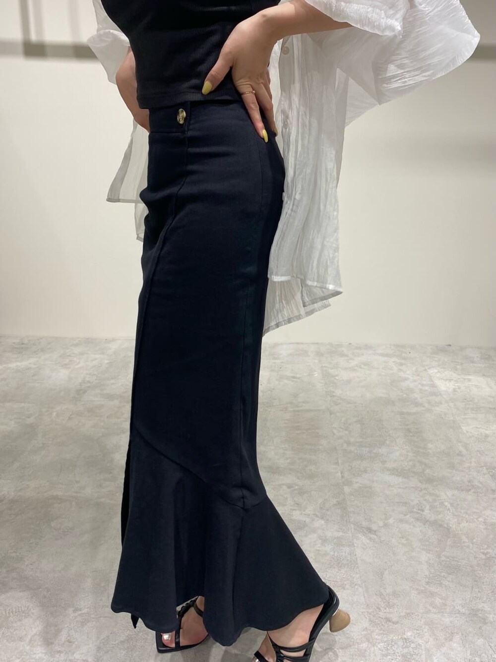 ブラック系のスカート、ホワイト系のシャツ/ブラウス、ブラック系のサンダルを着用したレディースの春コーディネートの7枚目の写真