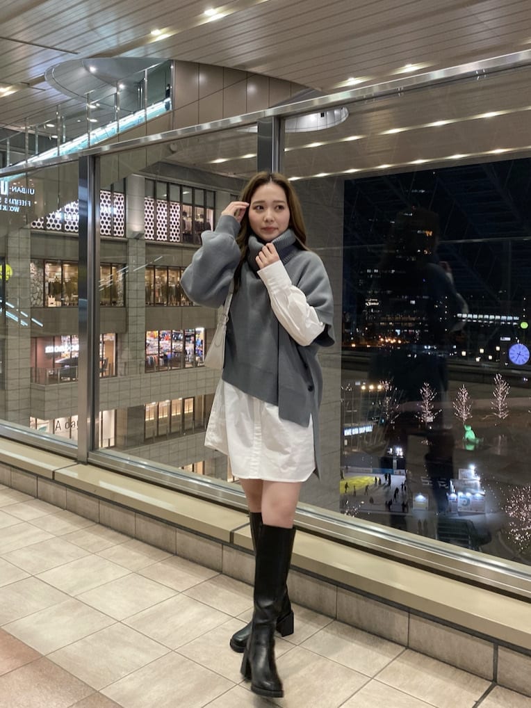 ホワイト系のハンドバッグ、ブラック系のブーツ、ブルー系のワンピースを着用したレディースの冬コーディネートの3枚目の写真