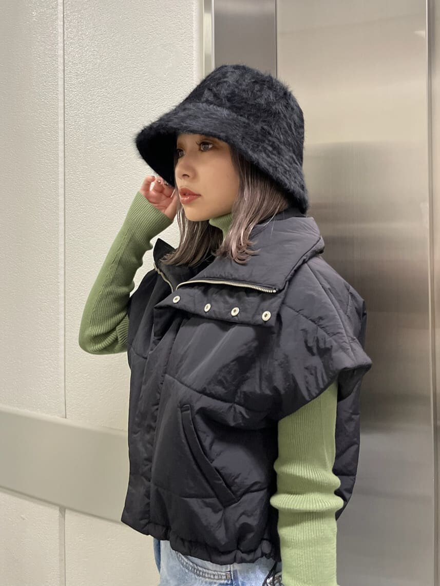 ブラック系のダウンベスト、グリーン系のニット/セーター、ブラック系のハットを着用したレディースの秋コーディネートの5枚目の写真