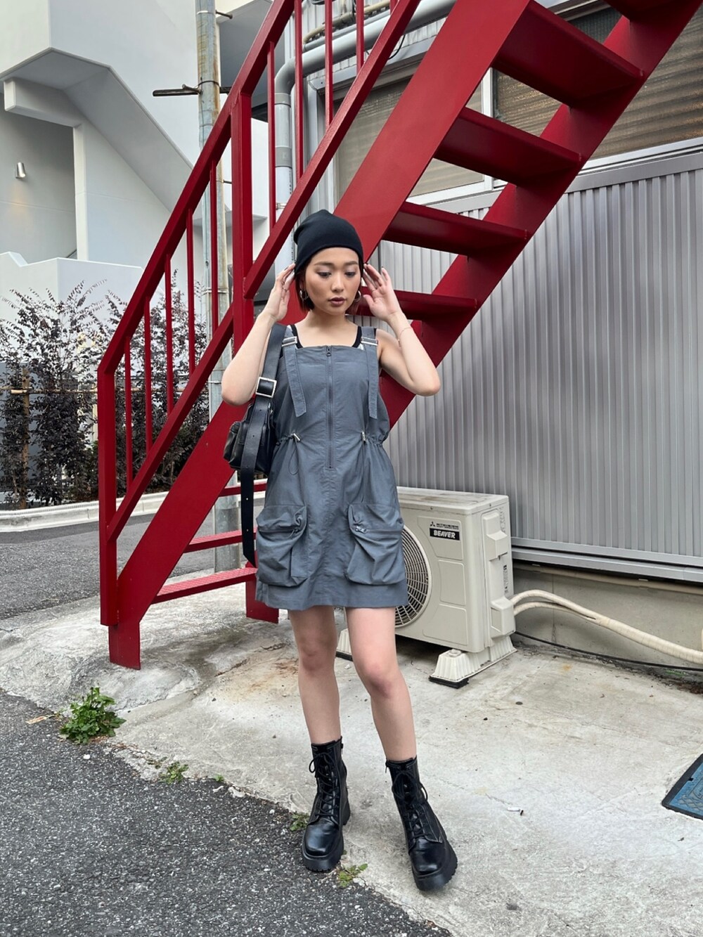 グレー系のワンピース、ブラック系のブーツ、ブラック系のタンクトップを着用したレディースの春コーディネートの3枚目の写真