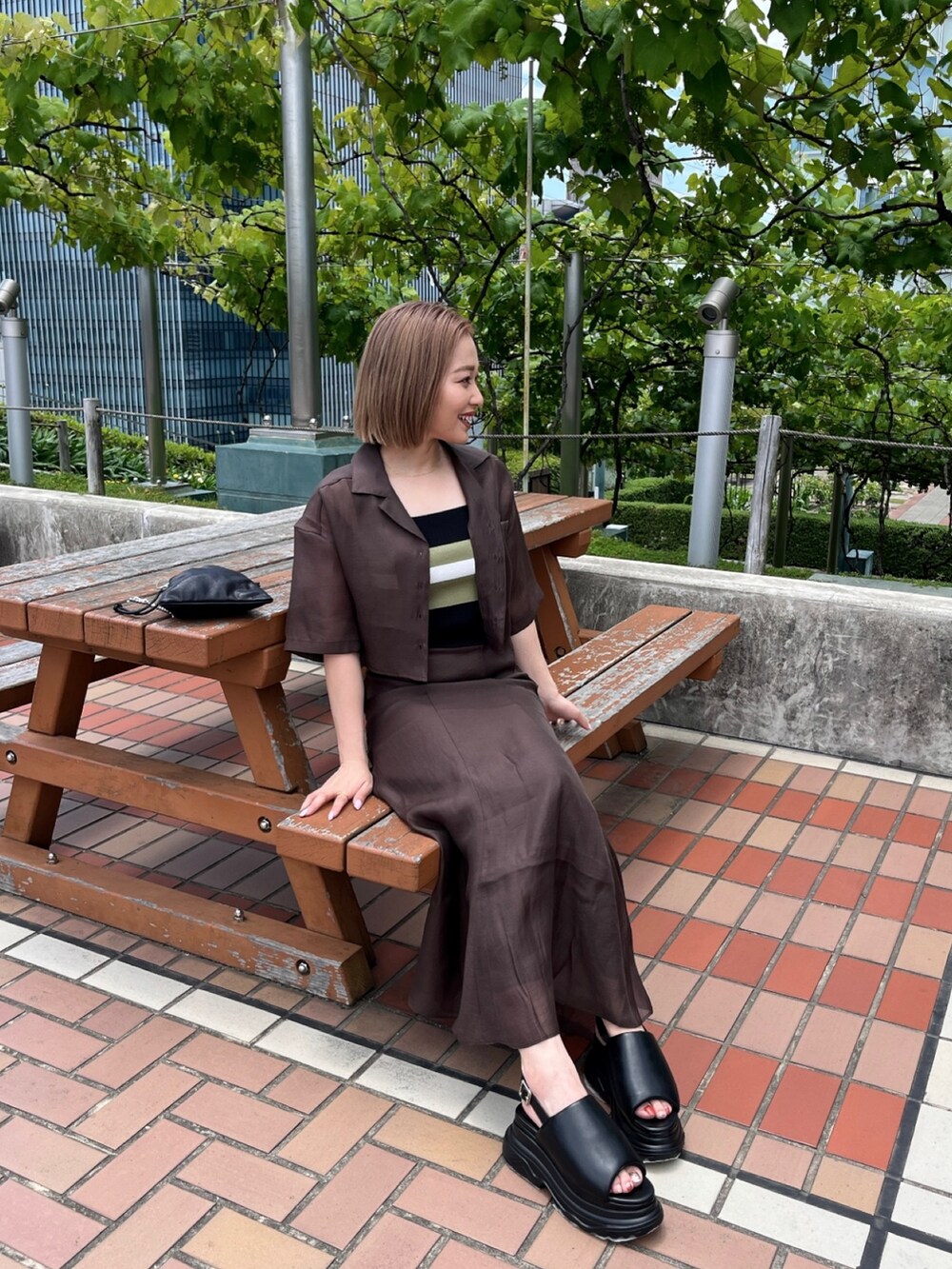 ブラウン系のシャツ/ブラウス、その他のニット/セーター、ブラウン系のスカートを着用したレディースの夏コーディネートの2枚目の写真