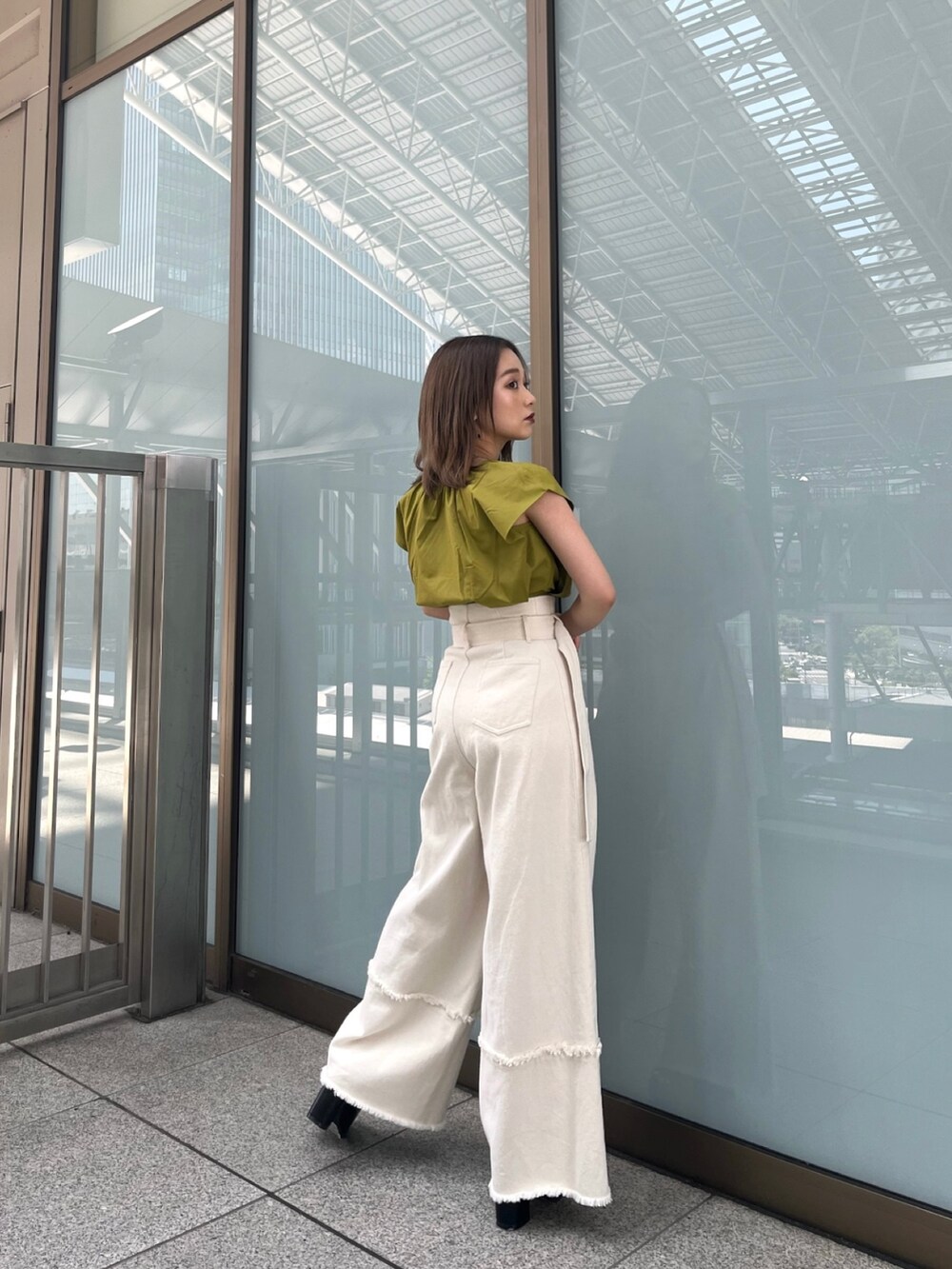 イエロー系のシャツ/ブラウス、ホワイト系のデニムパンツ、ブラック系のサンダルを着用したレディースの春コーディネートの2枚目の写真