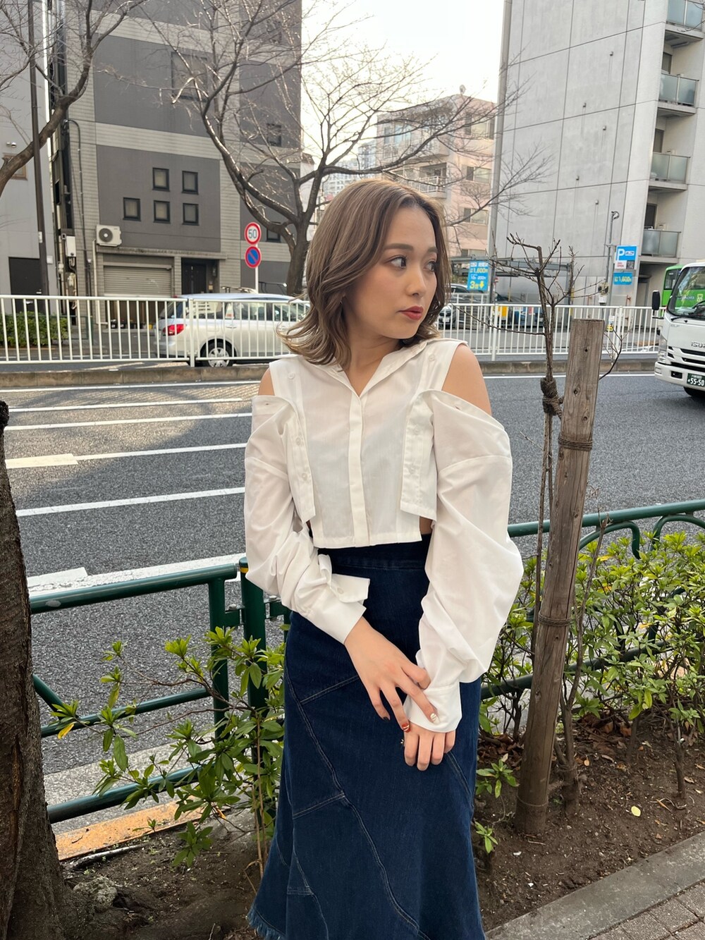 ホワイト系のシャツ/ブラウス、ブルー系のデニムスカート、ブラック系のサンダルを着用したレディースの春コーディネートの3枚目の写真