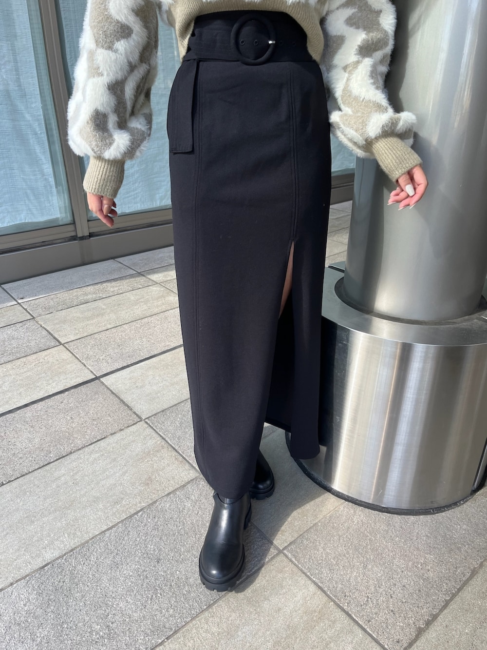 ベージュ系のニット/セーター、ブラック系のスカート、ブラック系のブーツを着用したレディースの秋コーディネートの8枚目の写真