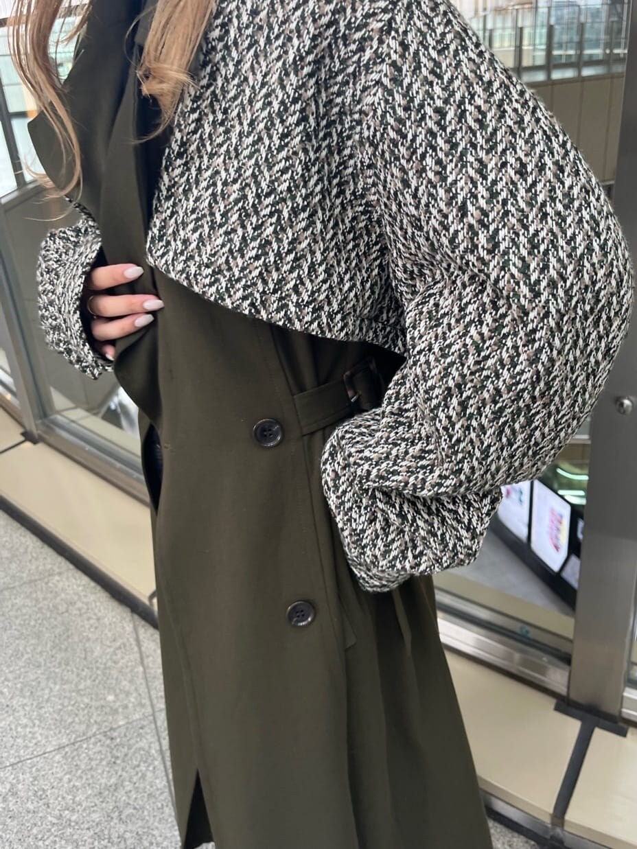 ブラック系のデニムパンツ、ブラック系のニット/セーター、ベージュ系のトレンチコートを着用したレディースの夏コーディネートの3枚目の写真