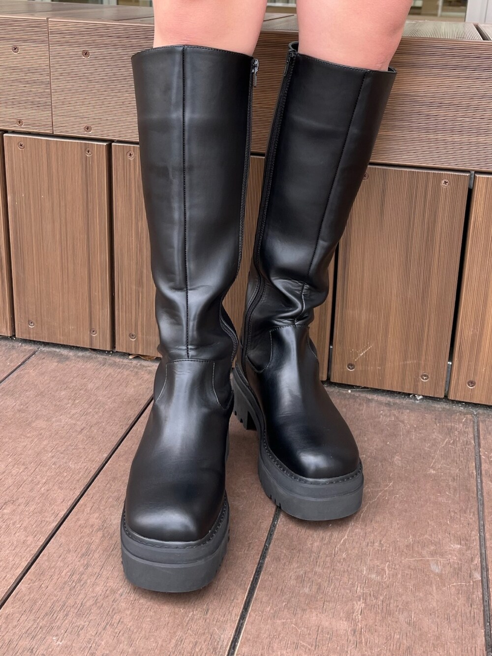グレー系のニット/セーター、ブラック系のスウェットパンツ、ブラック系のブーツを着用したレディースの冬コーディネートの9枚目の写真