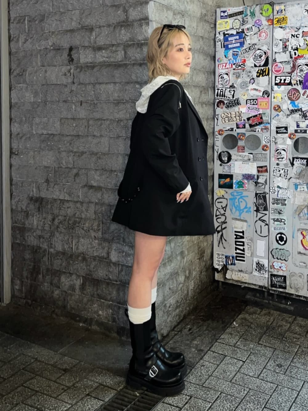 ブラック系のブーツ、ホワイト系のパーカー、ブラック系のテーラードジャケットを着用したレディースの春コーディネートの3枚目の写真