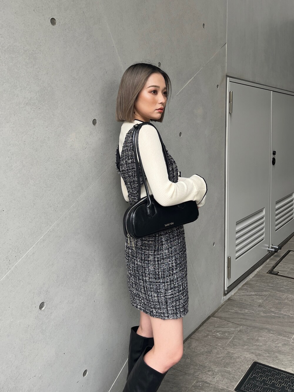 ホワイト系のニット/セーター、グレー系のワンピース、ブラック系のブーツを着用したレディースの秋コーディネートの6枚目の写真