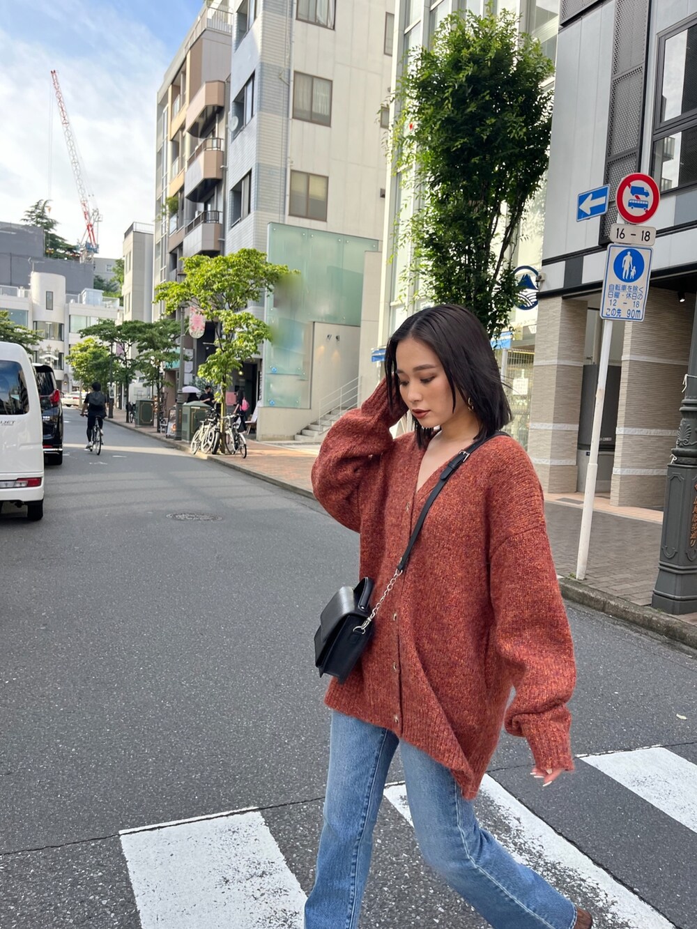 オレンジ系のカーディガン/ボレロを着用したレディースの夏コーディネートの2枚目の写真