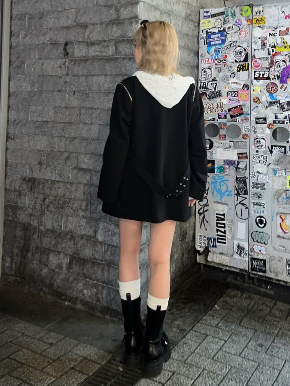 ブラック系のブーツ、ホワイト系のパーカー、ブラック系のテーラードジャケットを着用したレディースの春コーディネートの4枚目の写真