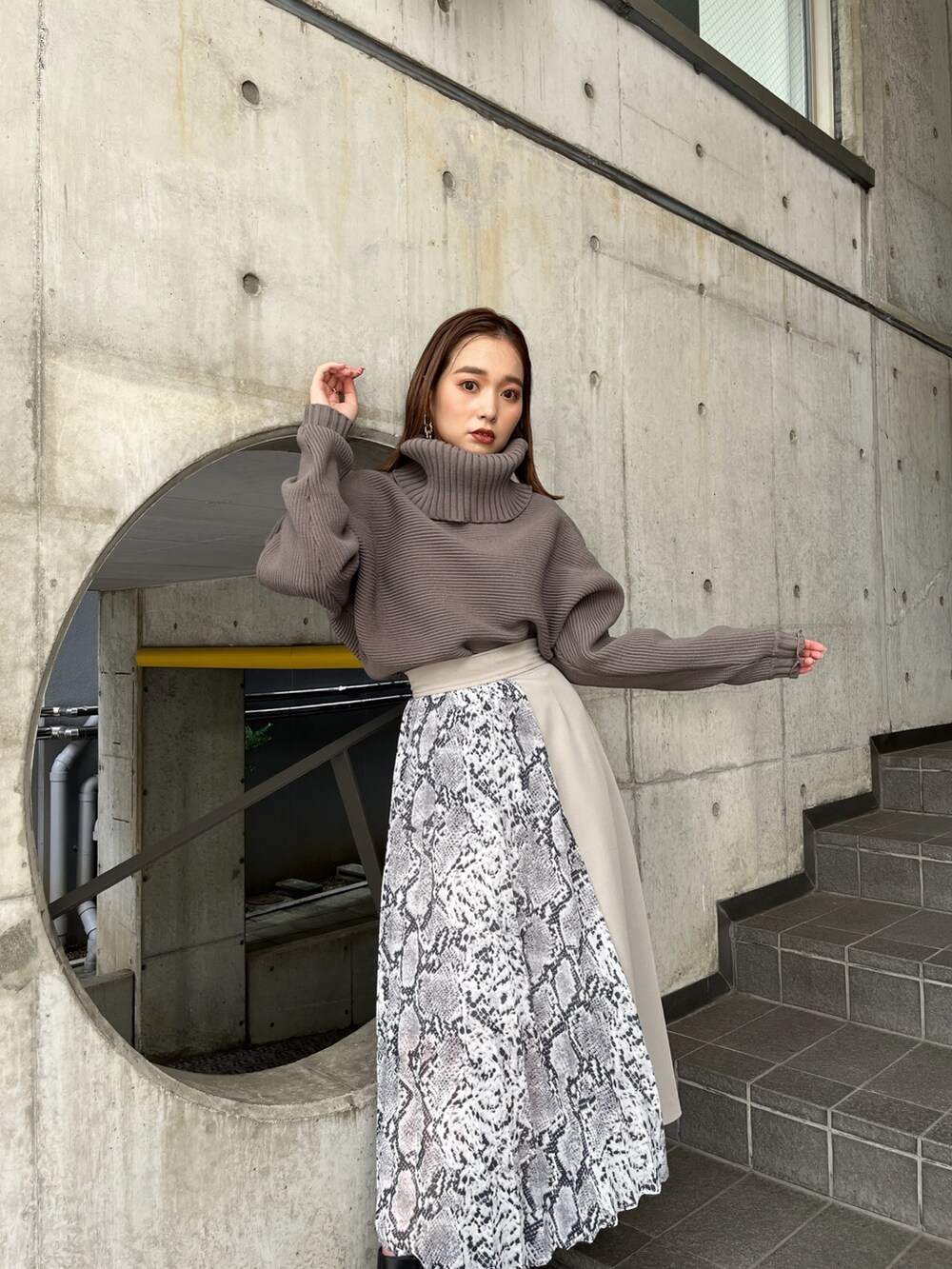 ブラウン系のニット/セーター、ホワイト系のスカート、ブラック系のブーツを着用したレディースの秋コーディネートの4枚目の写真