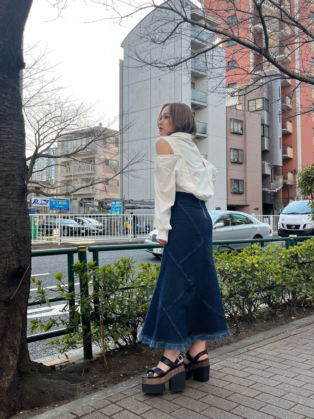 ホワイト系のシャツ/ブラウス、ブルー系のデニムスカート、ブラック系のサンダルを着用したレディースの春コーディネートの2枚目の写真