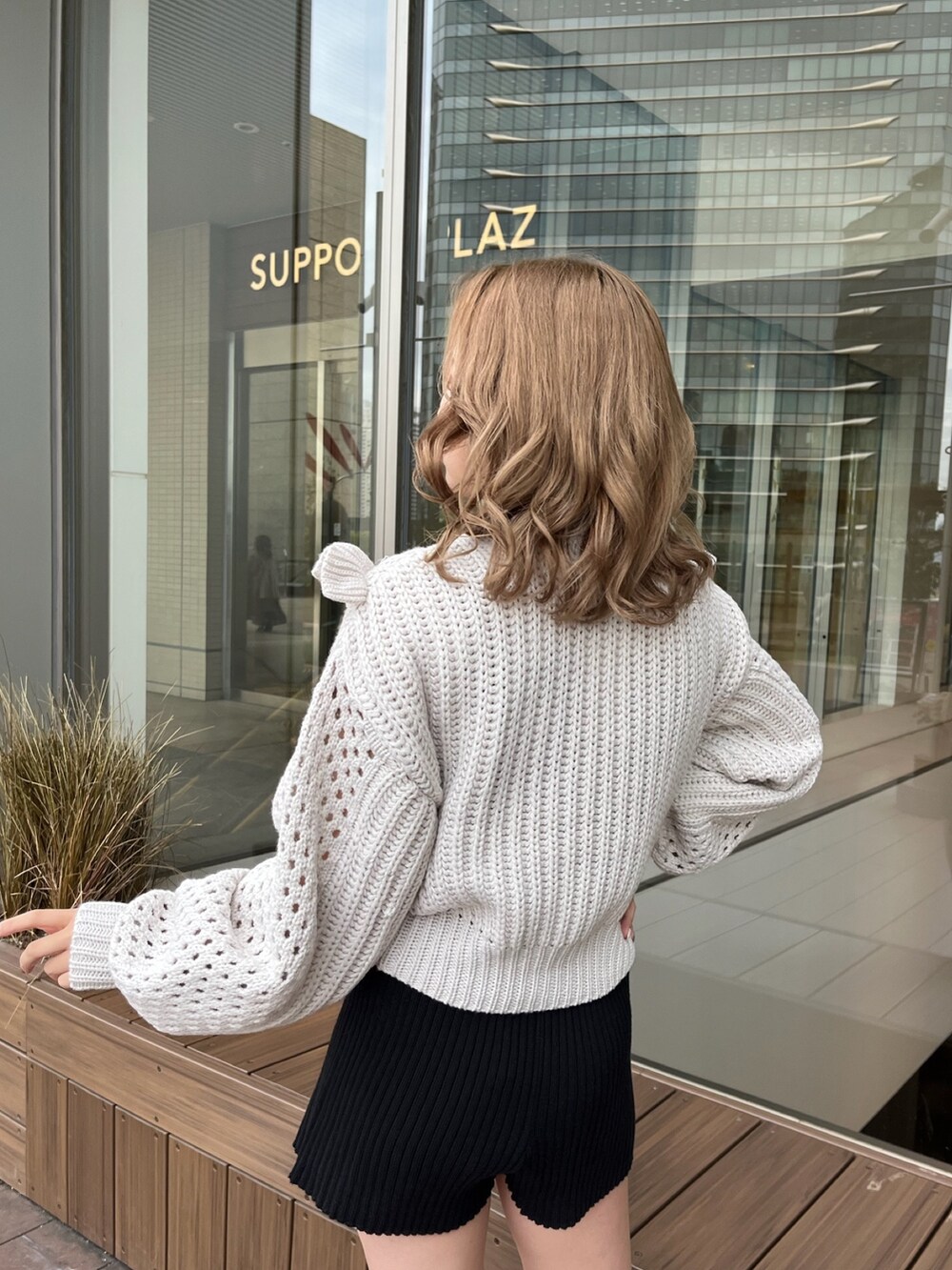 グレー系のニット/セーター、ブラック系のスウェットパンツ、ブラック系のブーツを着用したレディースの冬コーディネートの6枚目の写真