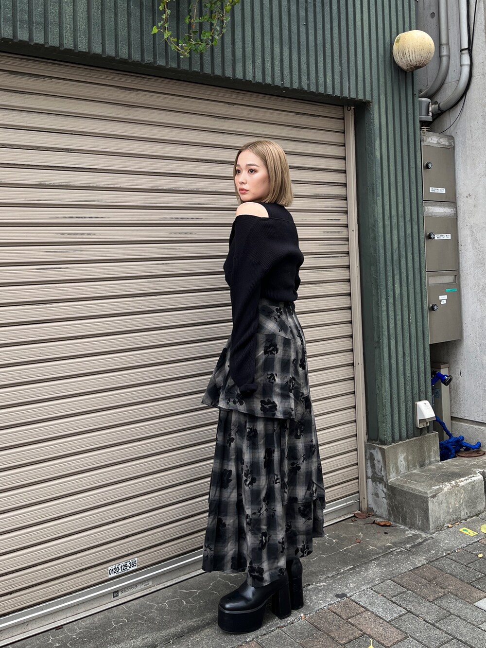 ブラック系のニット/セーター、ブラック系のスカート、ホワイト系のトートバッグを着用したレディースの冬コーディネートの3枚目の写真