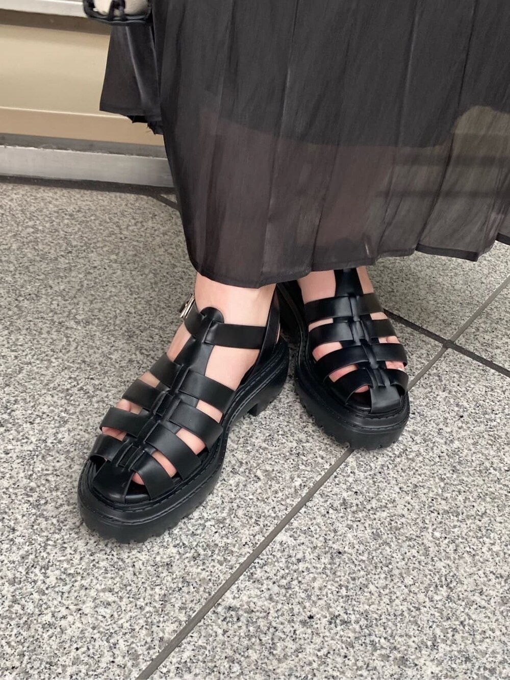 ブラック系のスカート、ブラック系のハンドバッグ、ブラック系のTシャツ/カットソーを着用したレディースの春コーディネートの7枚目の写真