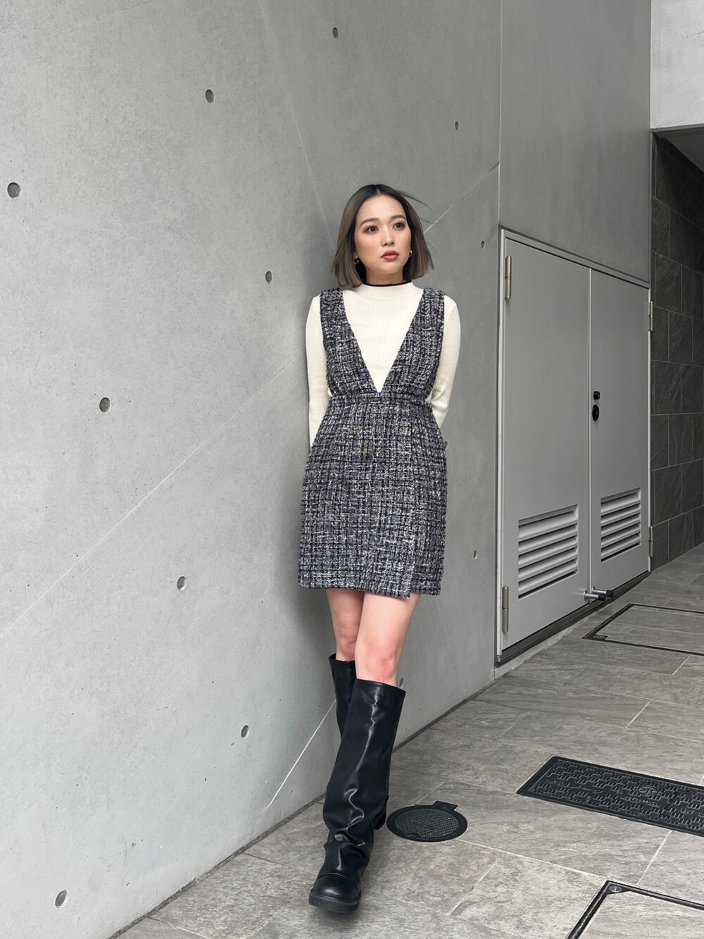 ホワイト系のニット/セーター、グレー系のワンピース、ブラック系のブーツを着用したレディースの秋コーディネートの2枚目の写真