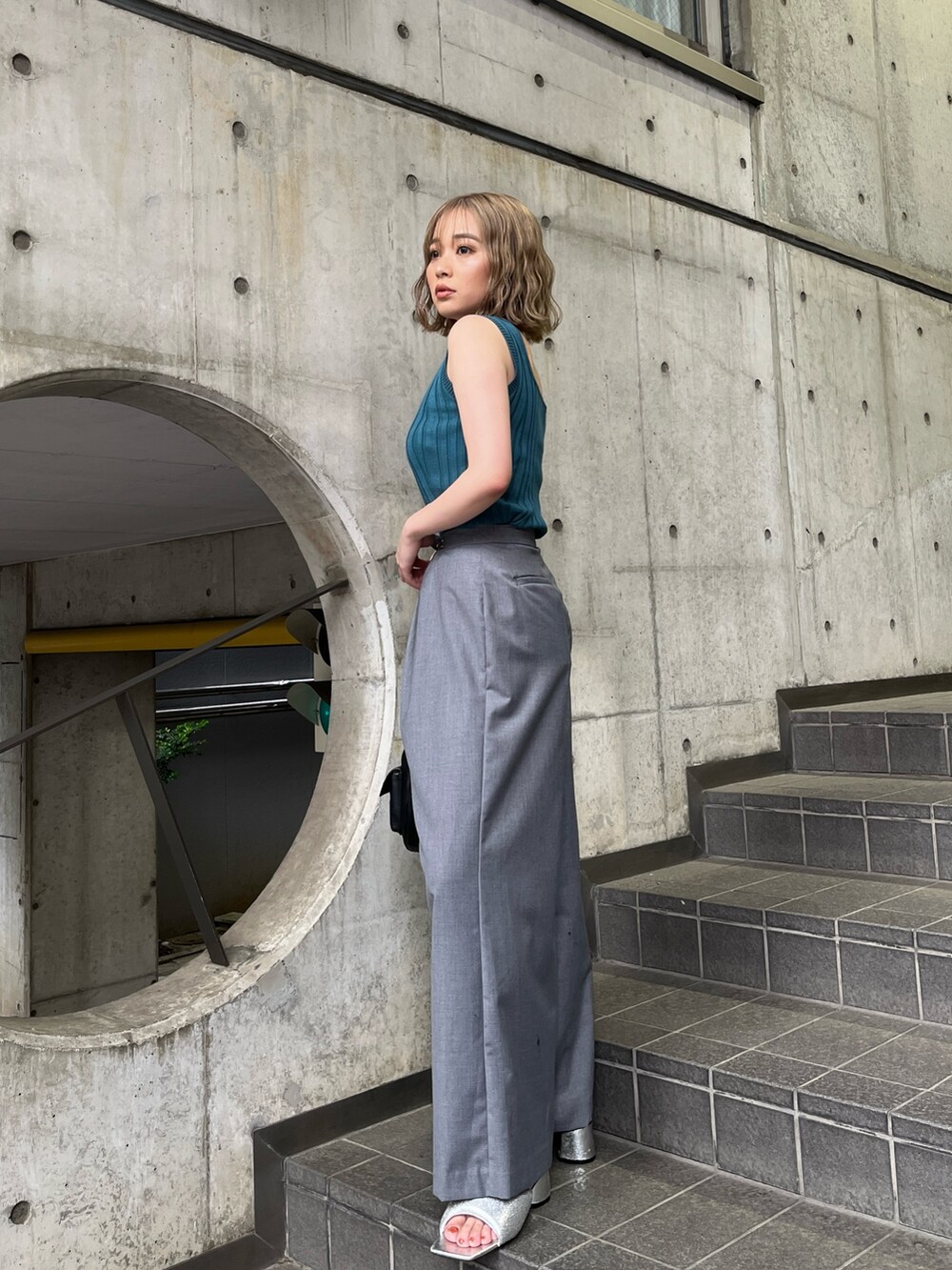 ブルー系のタンクトップ、グレー系のその他パンツ、ブラック系のハンドバッグを着用したレディースの夏コーディネートの2枚目の写真