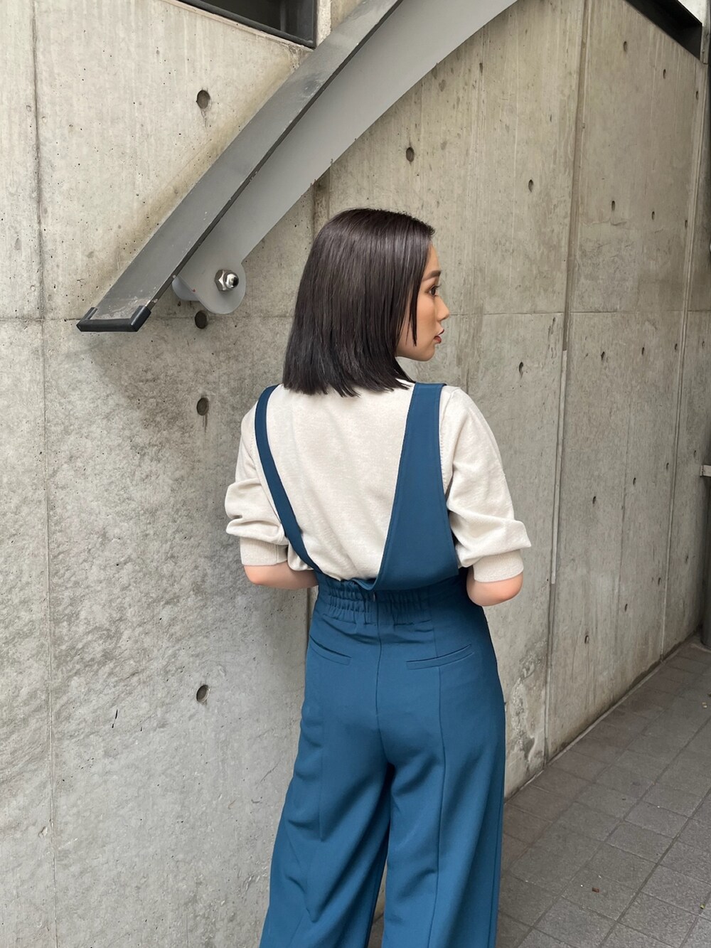 ブルー系のスラックス、ブラック系のブーツを着用したレディースの夏コーディネートの4枚目の写真