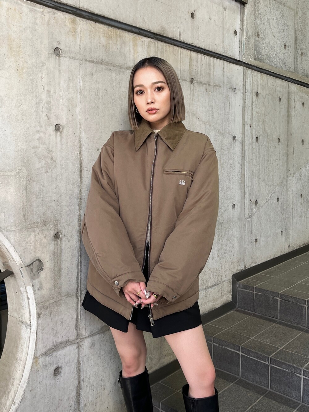 ブラウン系のブルゾン、ブラック系のブーツを着用したレディースの秋コーディネートの5枚目の写真