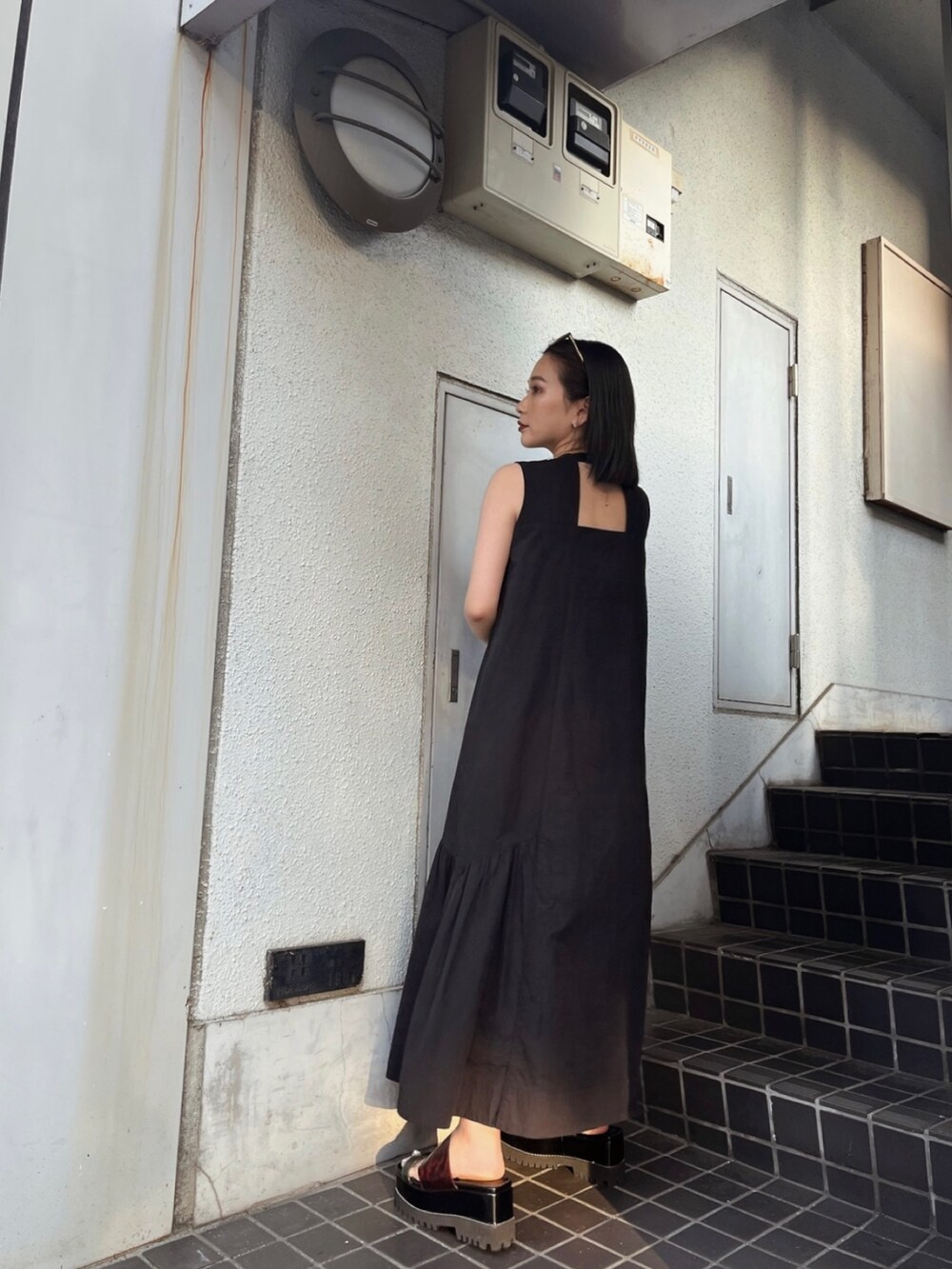 ブラック系のワンピース、その他のサンダルを着用したレディースの夏コーディネートの2枚目の写真