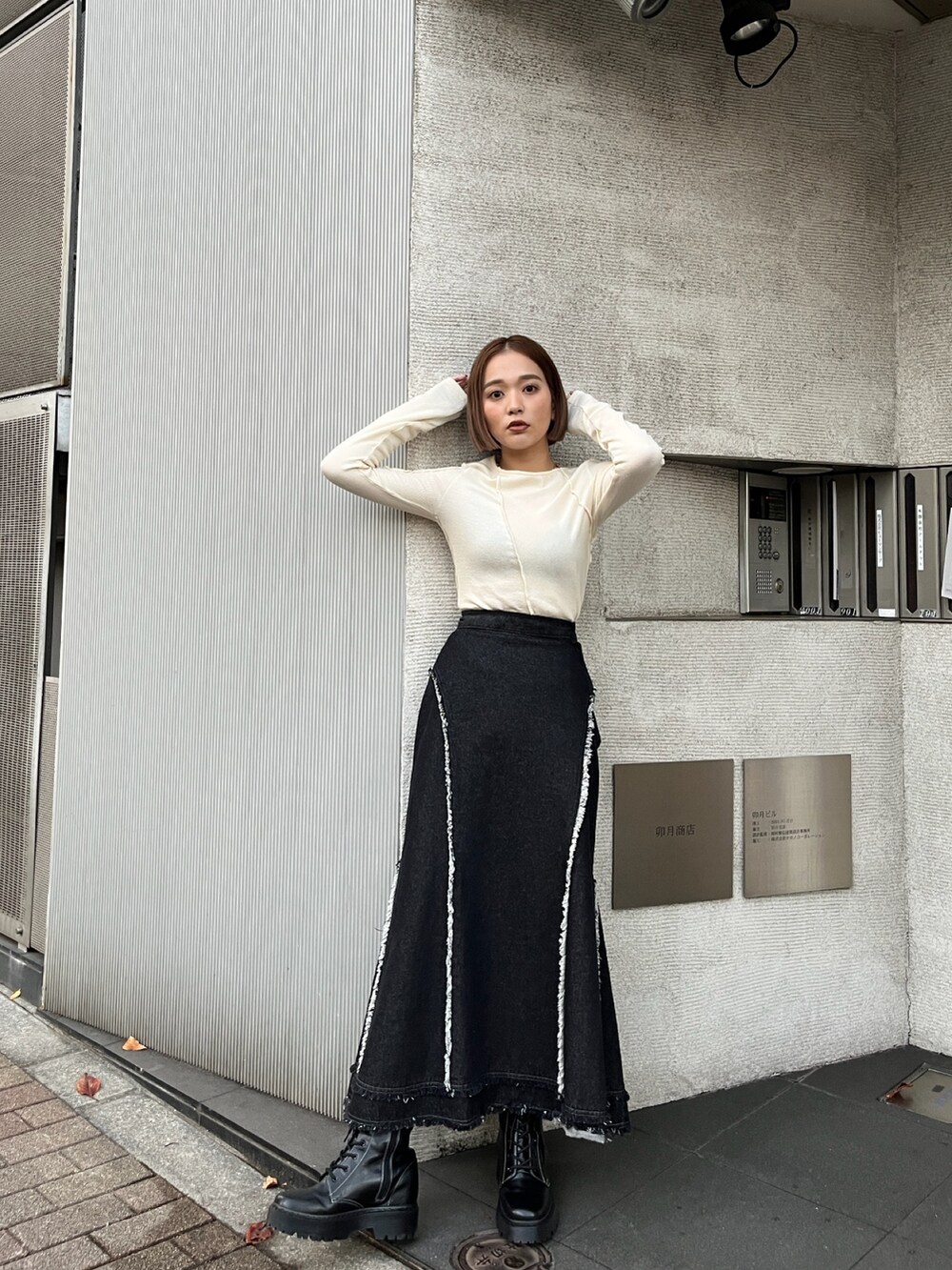ホワイト系のTシャツ/カットソー、ブラック系のデニムスカートを着用したレディースの秋コーディネートの2枚目の写真