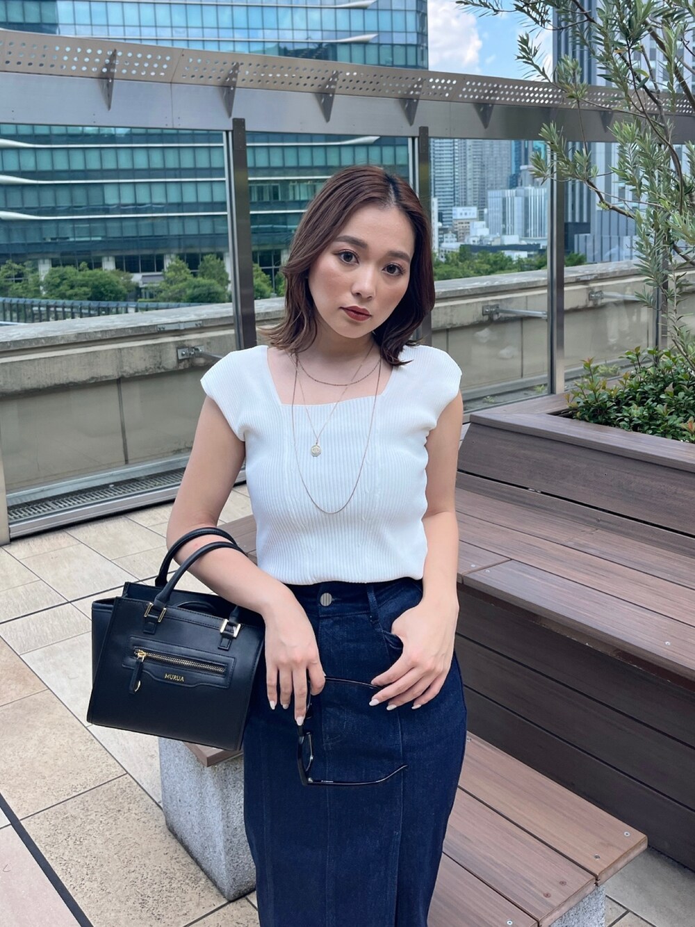 ホワイト系のタンクトップ、ブラック系のスカートを着用したレディースの夏コーディネートの3枚目の写真