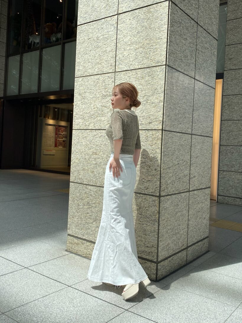 ホワイト系のキャミソール、ブラウン系のポロシャツ、ホワイト系のデニムスカートを着用したレディースの春コーディネートの4枚目の写真