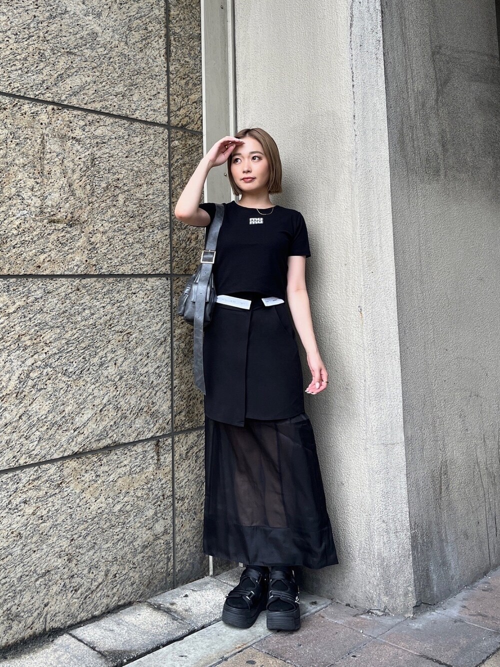 ブラック系のTシャツ/カットソー、ブラック系のスカート、ブラック系のサンダルを着用したレディースの夏コーディネートの3枚目の写真