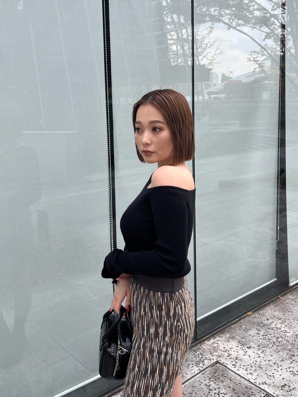 ブラック系のニット/セーター、ブラウン系のスカートを着用したレディースの冬コーディネートの2枚目の写真