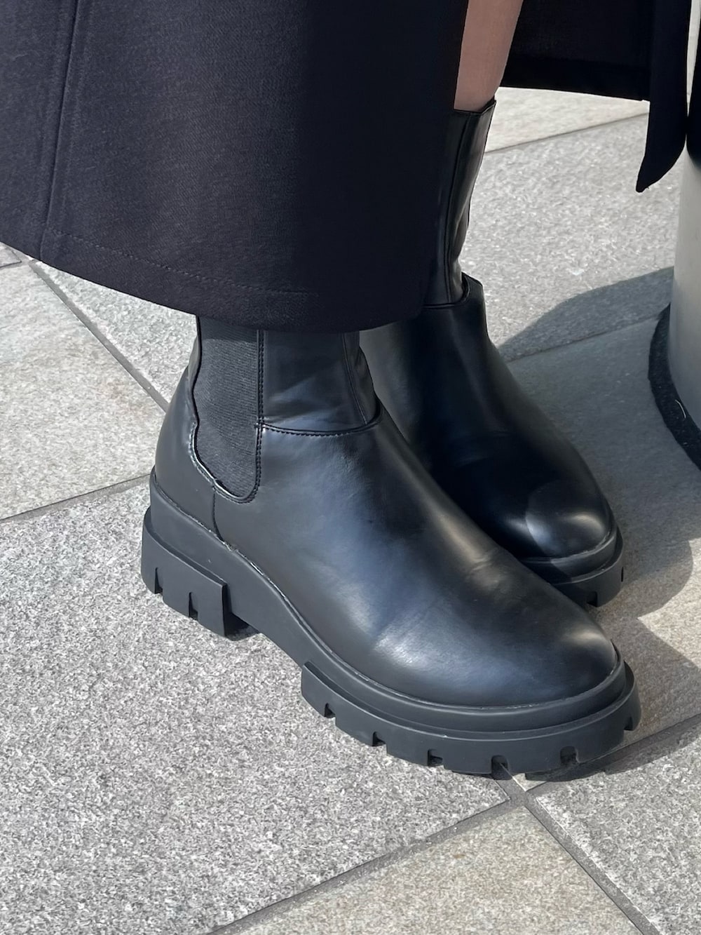 ベージュ系のニット/セーター、ブラック系のスカート、ブラック系のブーツを着用したレディースの秋コーディネートの9枚目の写真