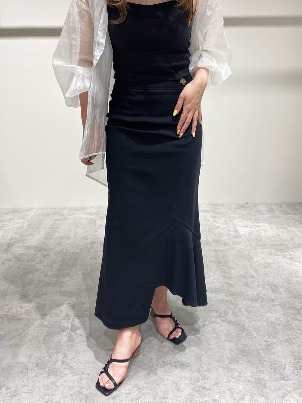 ブラック系のスカート、ホワイト系のシャツ/ブラウス、ブラック系のサンダルを着用したレディースの春コーディネートの6枚目の写真