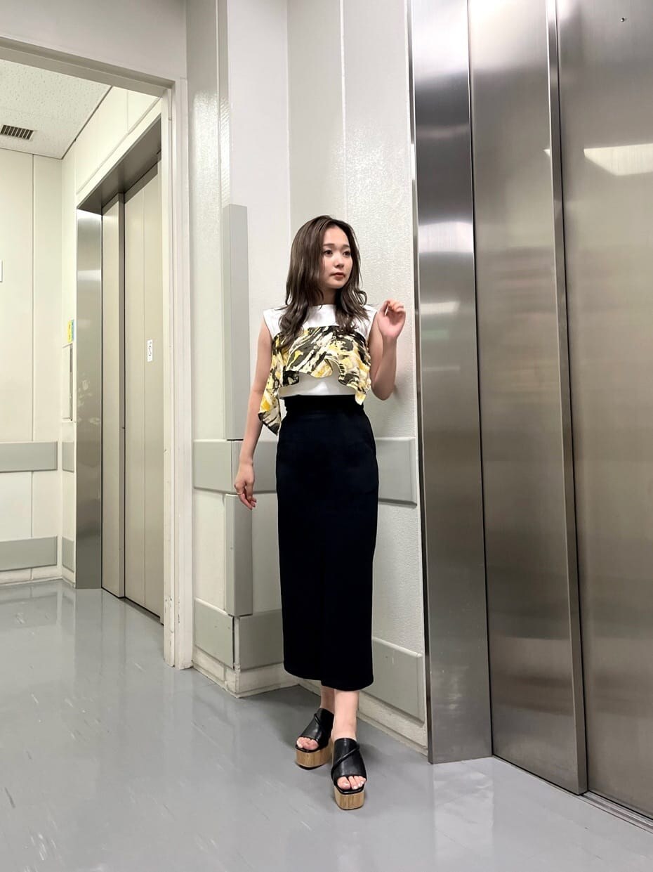 ブラック系のサンダル、ブラック系のスカート、ホワイト系のタンクトップを着用したレディースの夏コーディネートの2枚目の写真