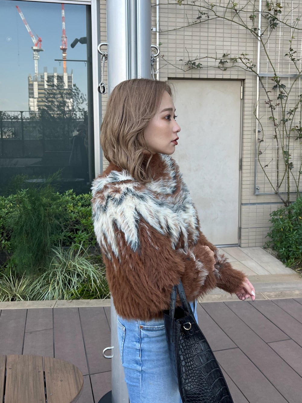 ブラウン系のニット/セーター、ブラック系のブーツを着用したレディースの冬コーディネートの5枚目の写真