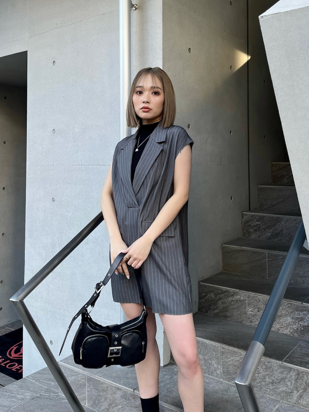 グレー系のワンピース、ブラック系のサンダル、ブラック系のニット/セーターを着用したレディースの夏コーディネートの4枚目の写真