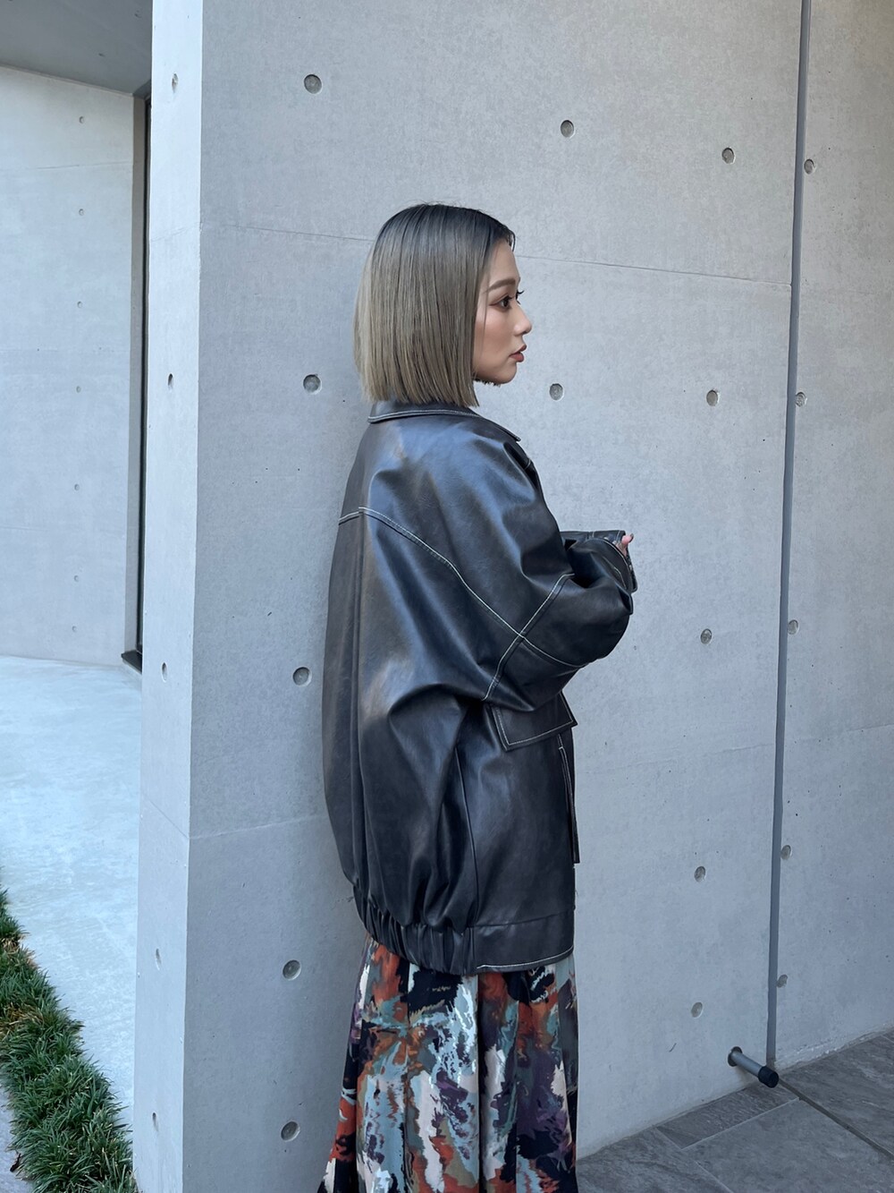 グレー系のブルゾン、ブラウン系のワンピース、ブラック系のブーツを着用したレディースの秋コーディネートの4枚目の写真