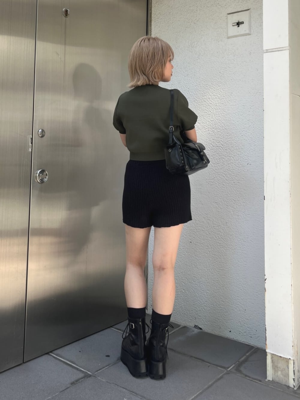 グリーン系のニット/セーター、ブラック系のその他パンツ、ブラック系のブーツを着用したレディースの秋コーディネートの2枚目の写真