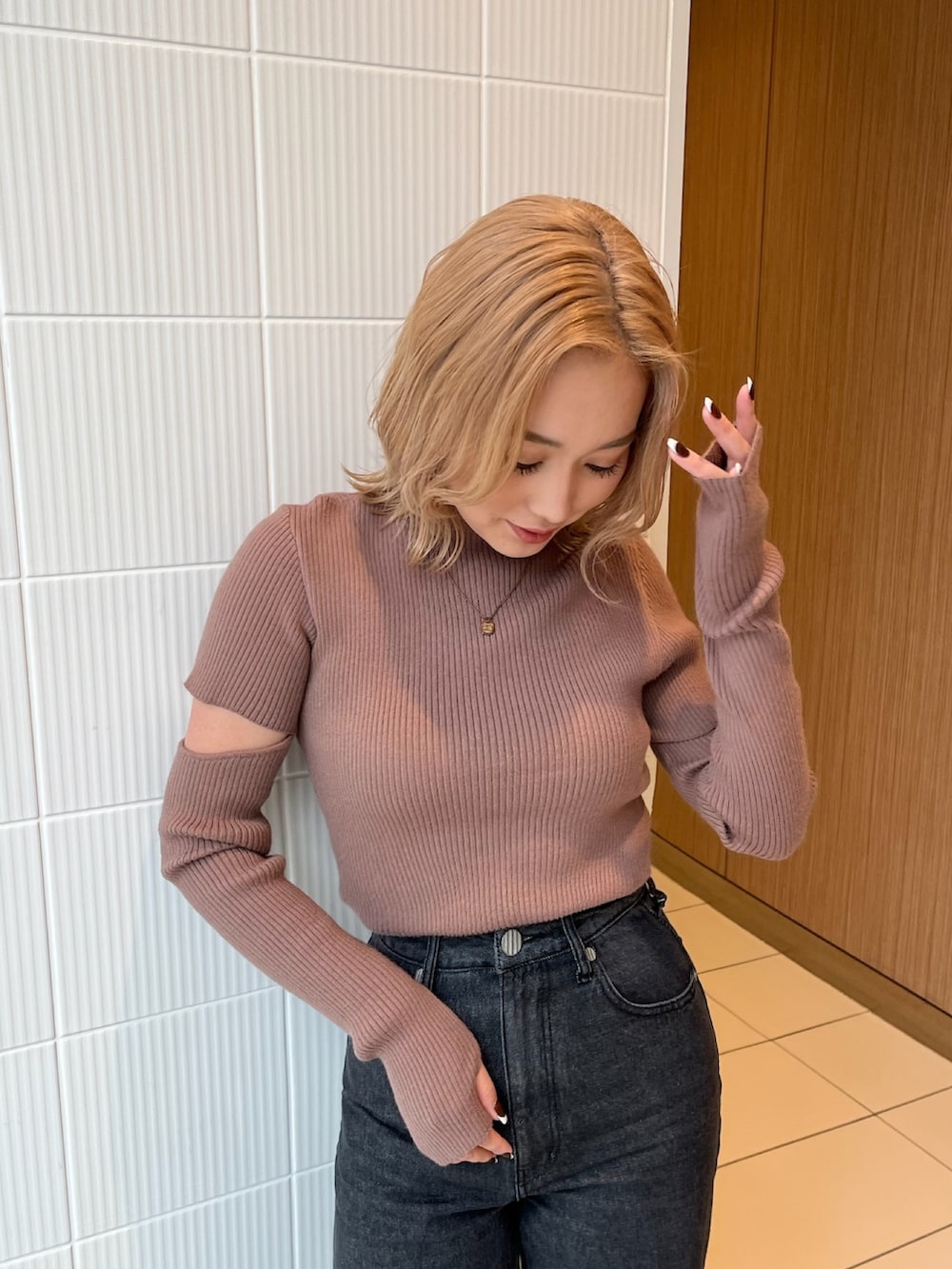 ブラック系のデニムパンツ、ブラウン系のニット/セーター、ブラック系のブーツを着用したレディースの冬コーディネートの5枚目の写真