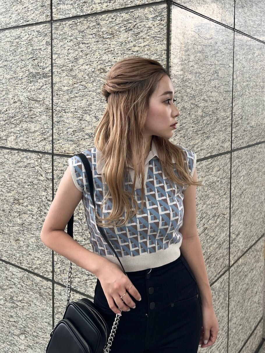 ブラック系のデニムパンツ、ブラック系のショルダーバッグ、ホワイト系のニット/セーターを着用したレディースの夏コーディネートの5枚目の写真