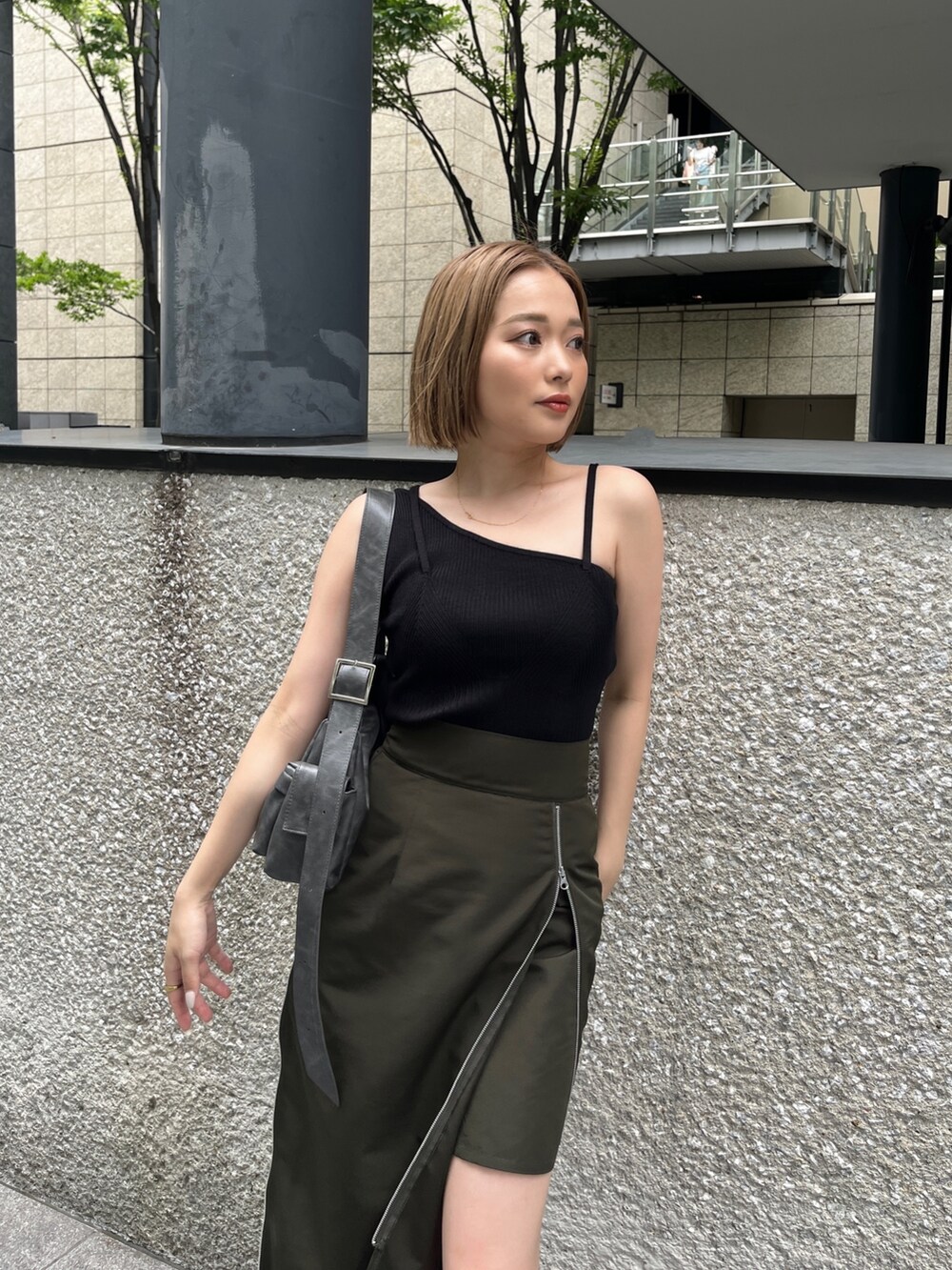 ブラック系のニット/セーター、グリーン系のスカート、グレー系のショルダーバッグを着用したレディースの夏コーディネートの5枚目の写真