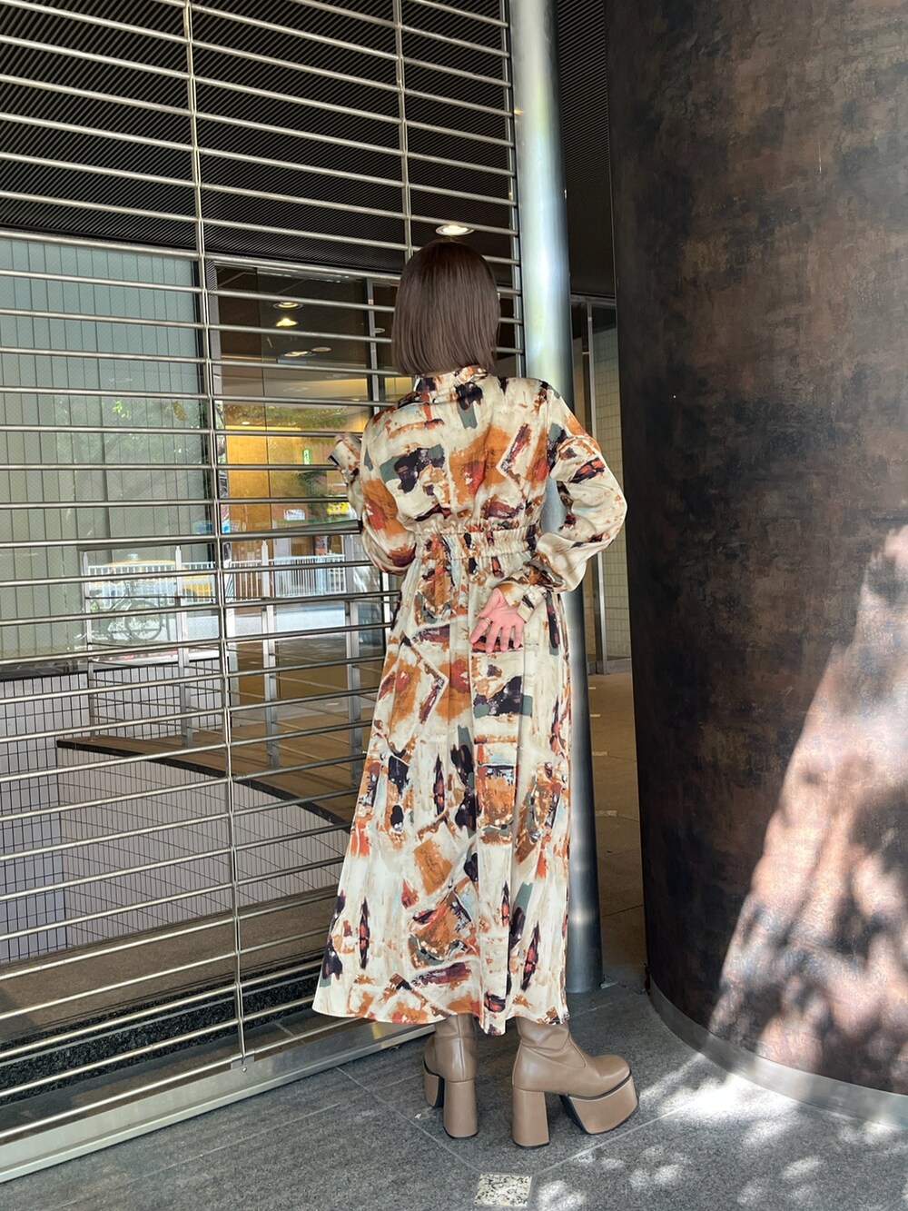 ブラウン系のブーツ、オレンジ系のワンピースを着用したレディースの秋コーディネートの3枚目の写真