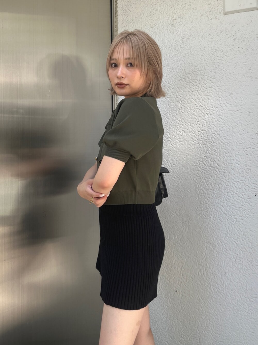 グリーン系のニット/セーター、ブラック系のその他パンツ、ブラック系のブーツを着用したレディースの秋コーディネートの5枚目の写真