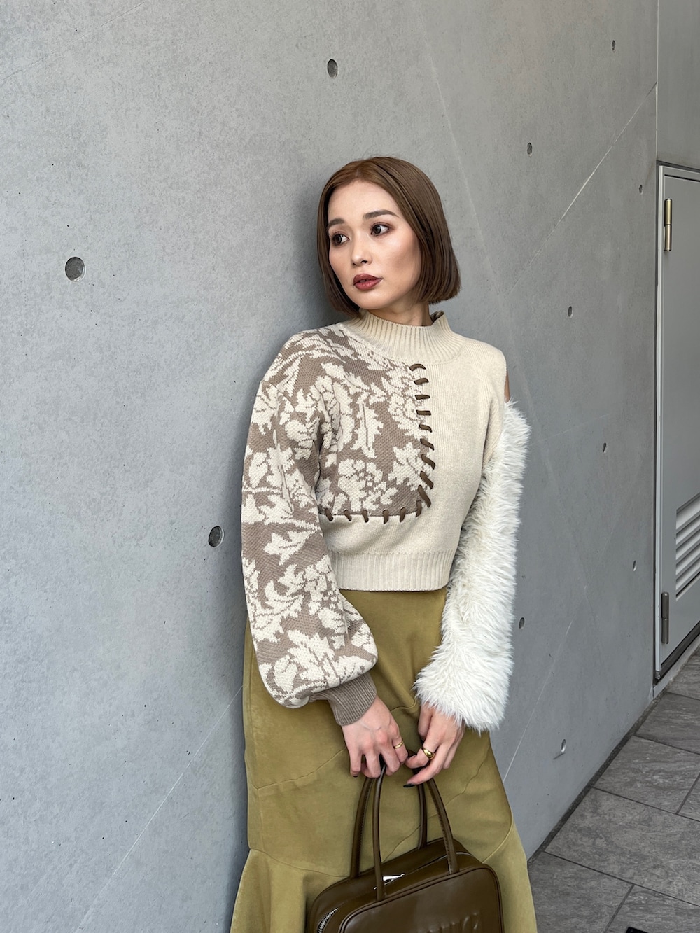 ホワイト系のニット/セーター、イエロー系のボストンバッグ、ホワイト系のブーツを着用したレディースの秋コーディネートの6枚目の写真