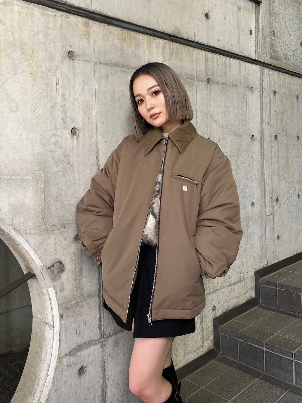 ブラウン系のブルゾン、ブラック系のブーツを着用したレディースの秋コーディネートの6枚目の写真