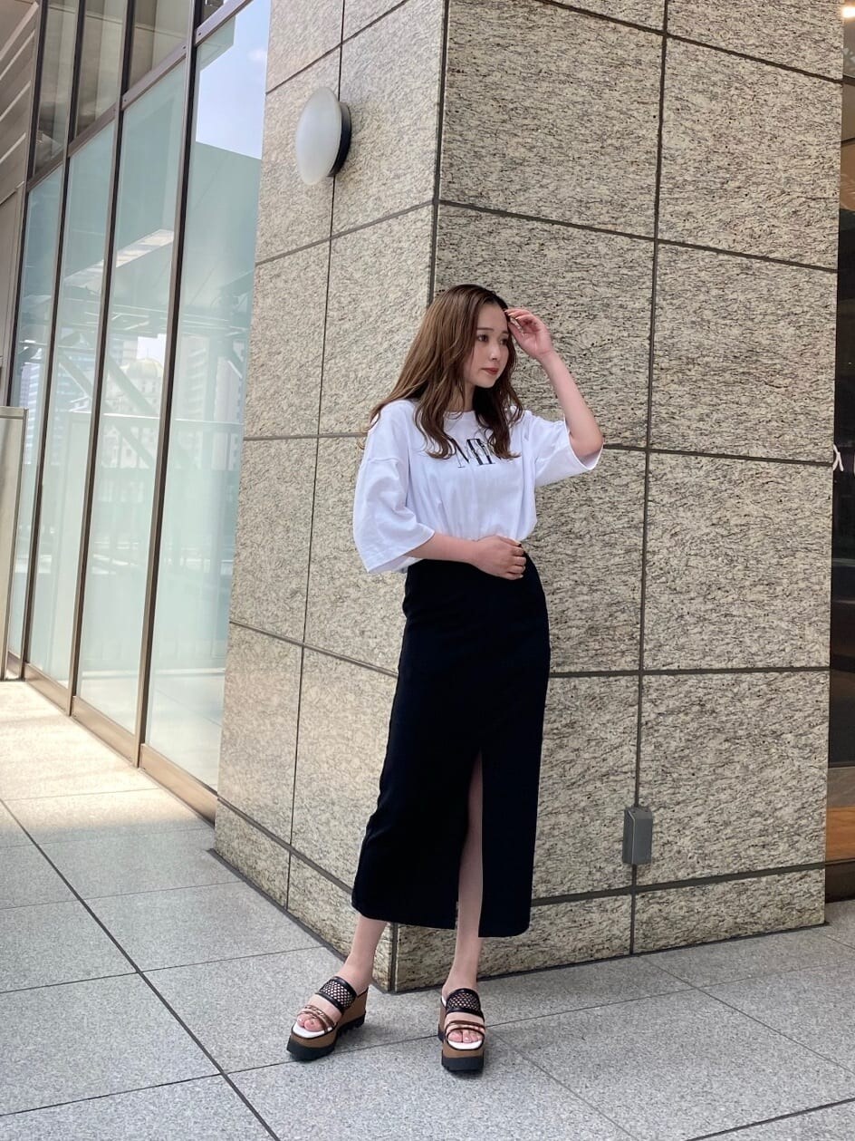 ブラック系のスカート、ホワイト系のTシャツ/カットソー、その他のサンダルを着用したレディースの春コーディネートの3枚目の写真
