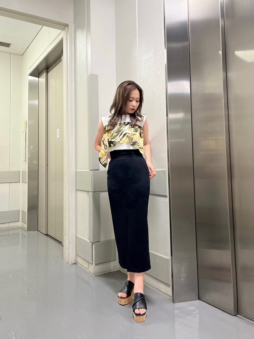 ブラック系のサンダル、ブラック系のスカート、ホワイト系のタンクトップを着用したレディースの夏コーディネートの4枚目の写真