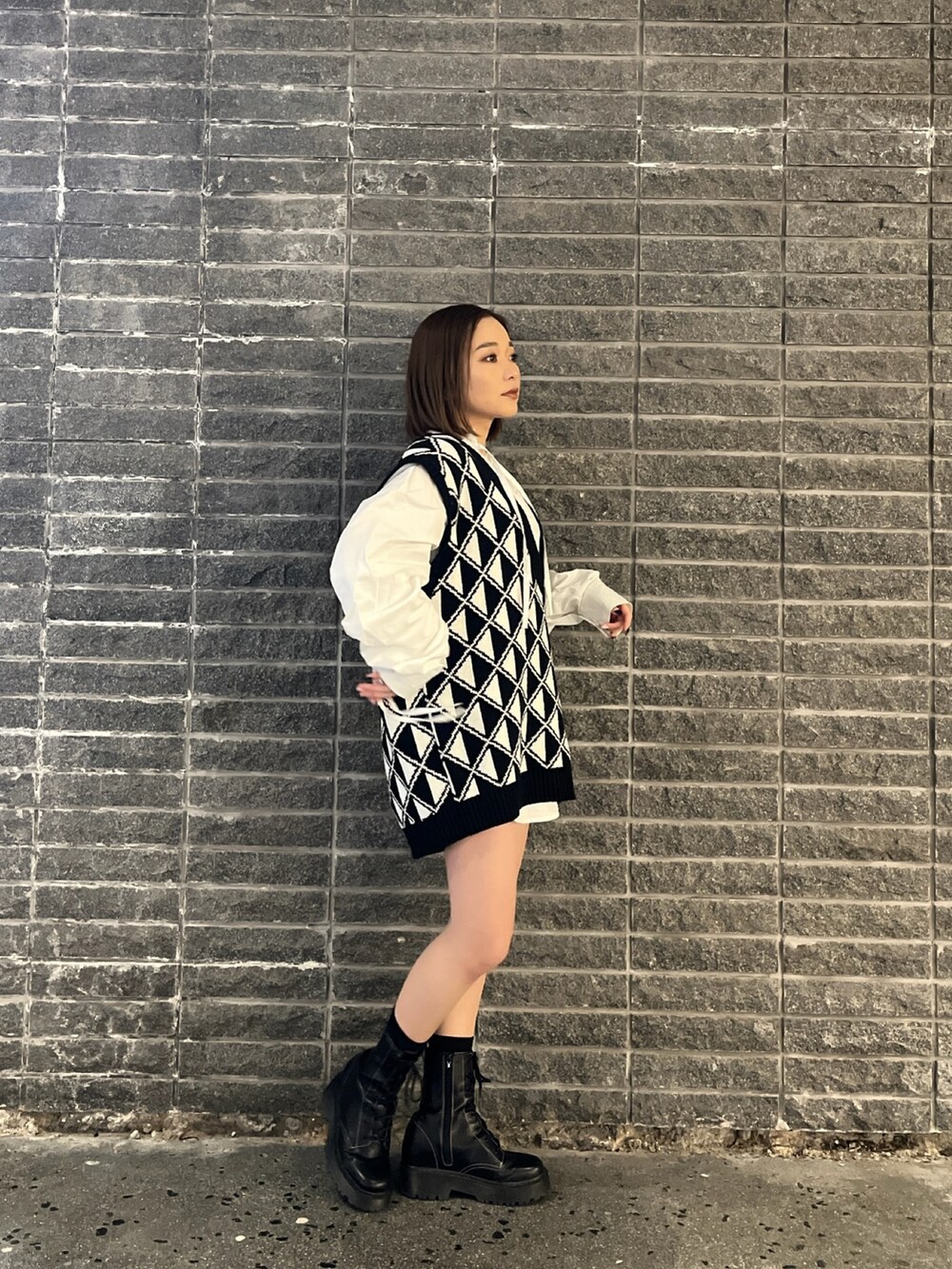 ホワイト系のシャツ/ブラウス、その他のベスト、ブラック系のブーツを着用したレディースの冬コーディネートの2枚目の写真